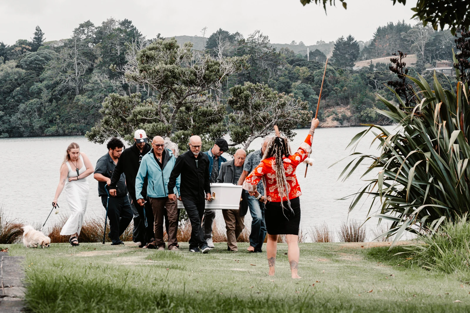 Family accompanying a funeral procession beside the water