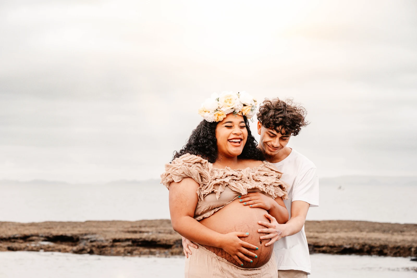 Logan and Tupou laughing together by the ocean