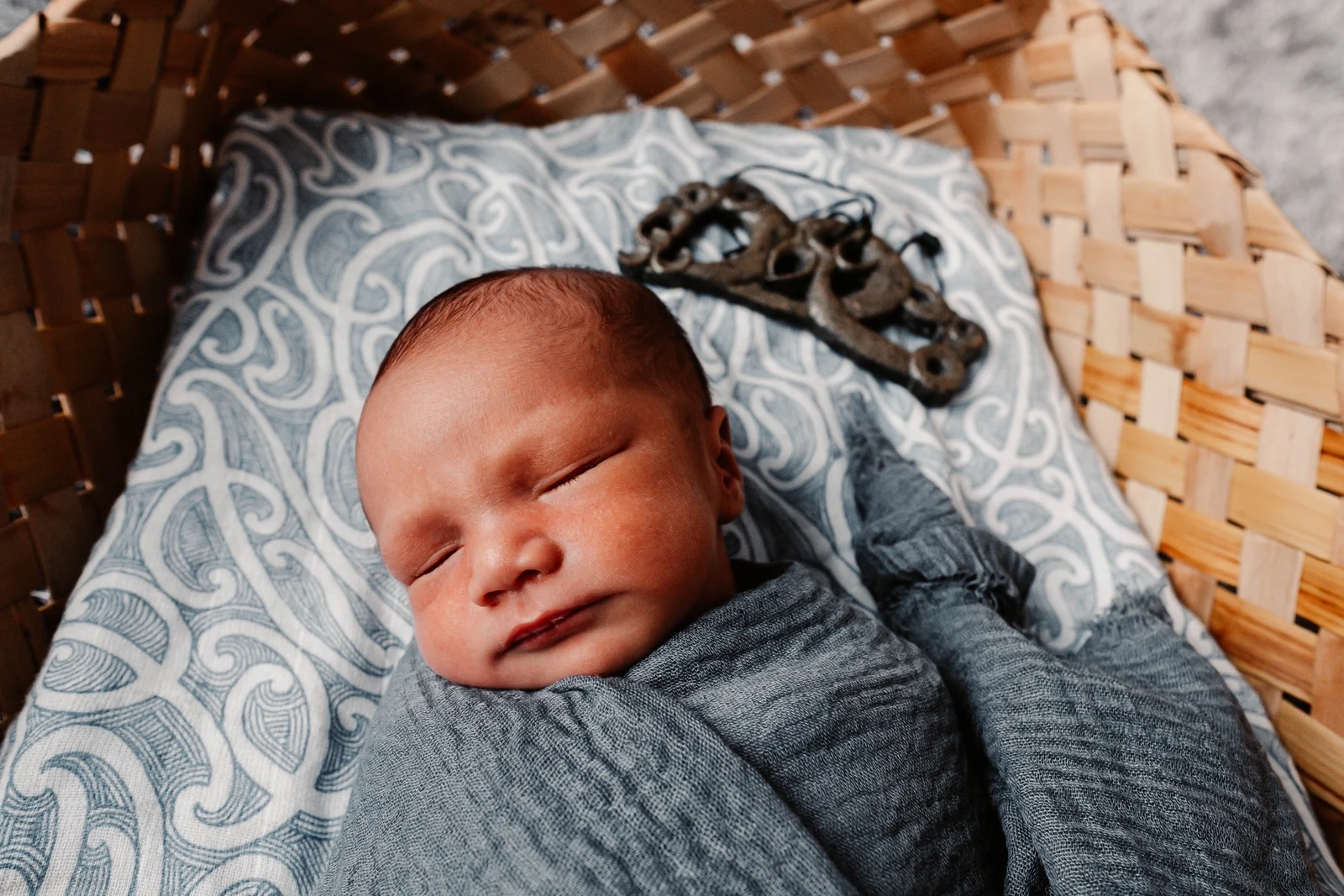 Sleeping newborn wrapped in a blanket in a woven basket